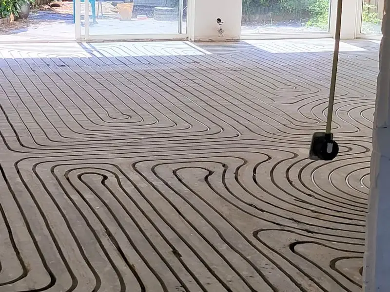 Ingefreesde vloerverwarming in een zandcementvloer tot aan de pui
