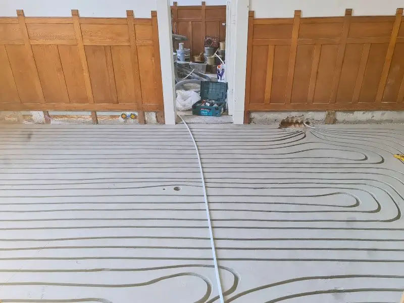 Ingefreesde vloerverwarming in een ruimte met houten lambrisering