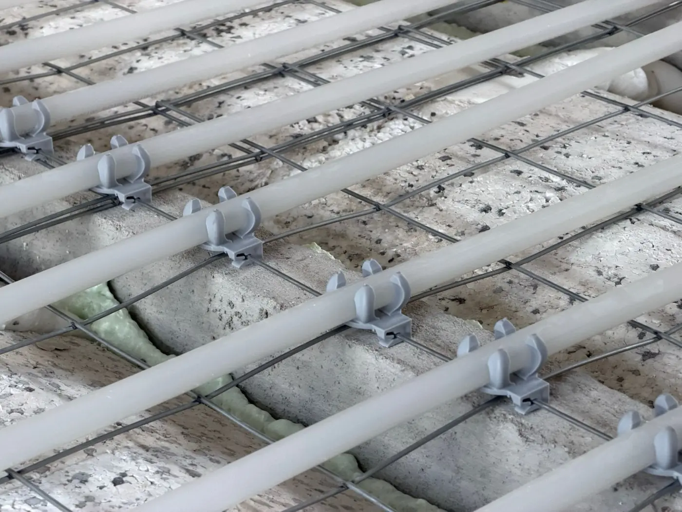 Vloerverwarmingsleidingen met kunststof clips vastgeklikt op krimpnetten