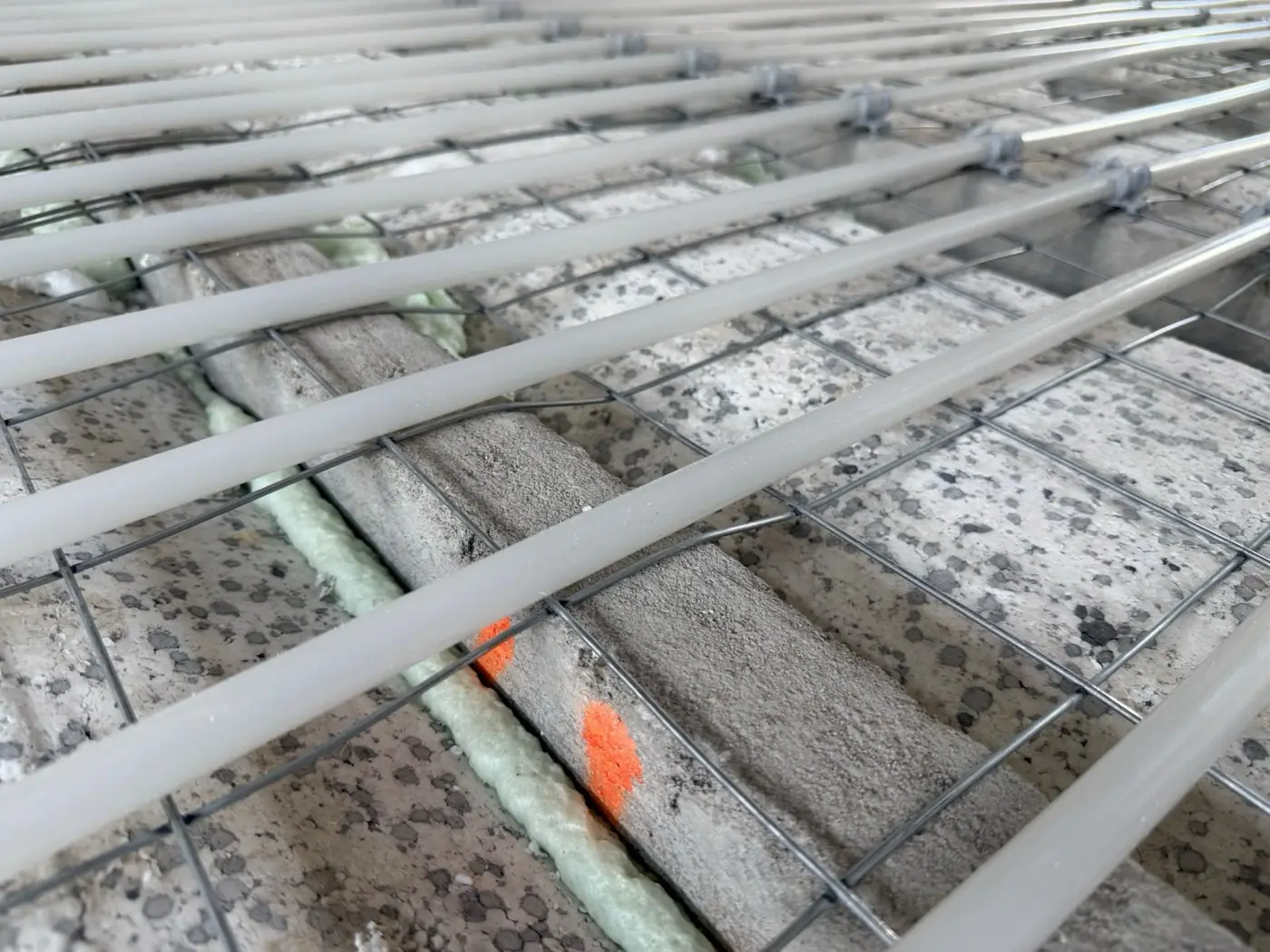 Vloerverwarmingsleidingen op krimpnetten boven isolatieplaten